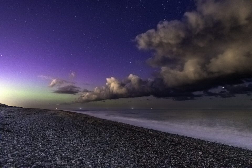 Small green and purple glow of Aurora at Newcastle beach